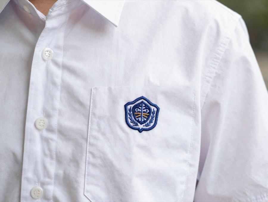 Detail bordir logo sekolah pada kemeja seragam konveksi Karmeda